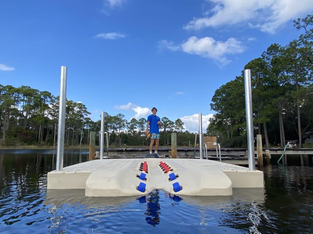 wave armor floating jet ski dock installed by Shoreman's Marine on the water near Mexico Beach with owner and operater posing for the camera
